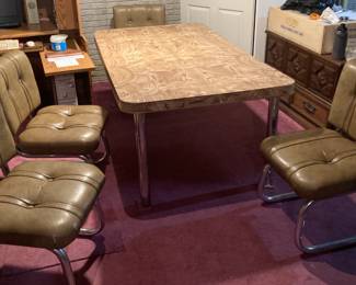 Vintage MCM Wood Grain Formica Table with Chrome Legs 6’x41.5”x29” Leaf is 17.5” wide. Includes 4 Vinyl Chairs.
