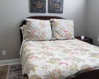 ANTIQUE FULL SIZE BED WITH FLORAL MOTIF LINENS AND METAL CROWN WALL PLAQUES