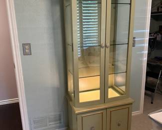 Four shelf lighted curio cabinet with storage underneath.