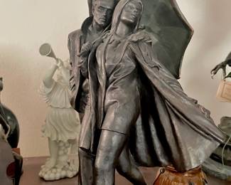 Metal Sculpture of Couple Walking in Rain by Andres Peralta