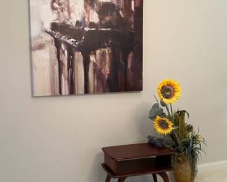 Grand piano wall art. MCM table. Faux sunflowers in ceramic urn.