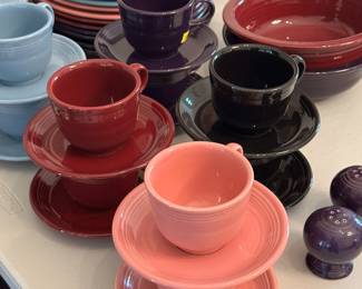 Homer Laughlin Fiesta plates, bowls, cup and saucer sets in sky blue, maroon, salmon pink, purple and dark green colors.