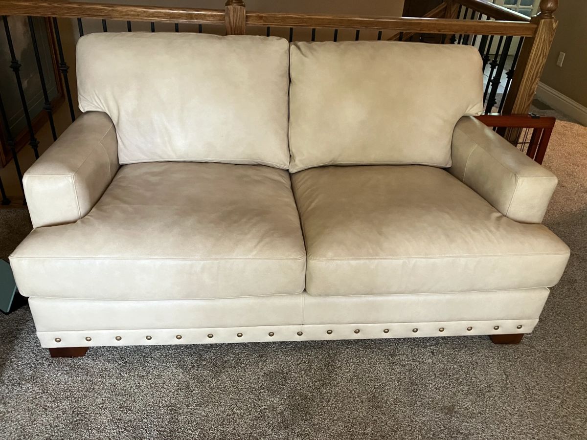 Cream leather loveseat w brass tack trim