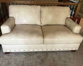 Cream leather loveseat w brass tack trim