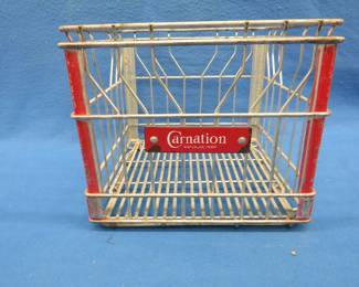 Lot 155. Metal milk crate from Carnation.&nbsp; Has a porcelain name plate.