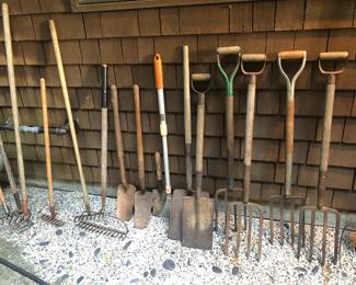 Lots of yard tools: rakes, shovels & pitchforks