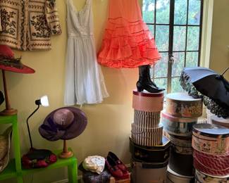 Design Within Reach, Cubitec modular shelving system.
Hanging above, far left is a darling west Germany vintage wool sweater with mother of pearl shell buttons, sweater is in mint condition. Two vintage slips.  Victorian pair of leather boots. Lovely antique Victorian mourning umbrella. Over a dozen fun vintage hat boxes, several of them having local Midwest shops and cities on them.