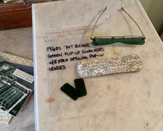 Including a pair of 1960s “Pat Boone” flip-up green sunglasses! With sleek case