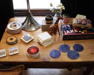 Collection of lovely coasters shown with a poker chip set and a box of vintage safety matches