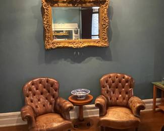 Pair of Ralph Lauren Home button tufted leather chairs (one seat with tear), Massive Antique English Carved and Gilded Beveled Mirror and Biedermeier style side table with birds-eye maple top