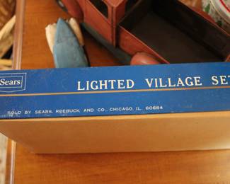 Side view of vintage Sears Lighted Village Christmas Set, contains eleven houses, one church, and twelve miniature light set with two spare lamps
