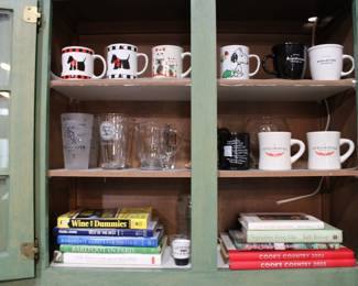 Assorted drinkware and cookbooks including Scottie dog and Intelligentsia coffee mugs and Chicago Sox Champions commemorative cup