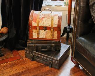 World map storage chest shown with two vintage hard side leather suitcases