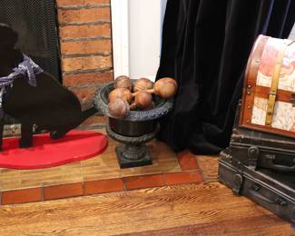 Antique wooden dumbbell weights shown in a cast iron urn planter vase