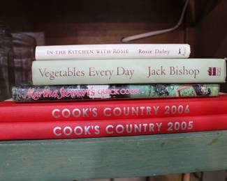 Assorted cookbooks including Cook's Country 2005, Cook's Country 2006, Martha Stewart's Quick Cook, Vegetables Every Day, In the Kitchen with Rosie