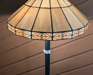 Lot 616: Metal floor lamp with slag glass leaded shade; measures 60 " high to top of the finial