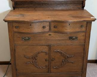 Lot 100: Antique double bow front oak chest featuring two small drawers, long drawer and storage behind two doors below, carved raised gallery; surface of chest measures 56 " high to top of raised gallery, 38.5 " high to top of surface x 44 " wide x 22 " deep