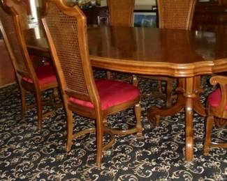 Dining table w/pads, 2 leaves, & 6 matching cane back chairs. Table: 112" L x 47"W x 30" T (w/leaves in). 72" L x 47" W x 36" T w/o leaves.