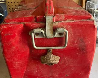 SIDE OF COOLER WITH COCA COLA BOTTLE OPENER ON IT