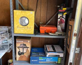 DVD PLAYER NEW IN BOX, PORCH LIGHT NEW IN BOX, LAWN DECOR NEW IN BOX, BATTERY CHARGER, METAL SHELF, FIRE EXTINGUISHER AND OTHER MISC