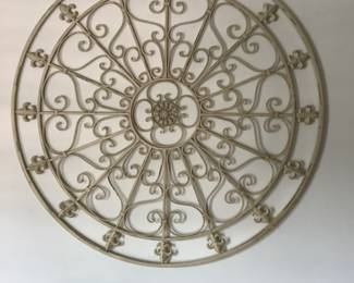Round metal wall art measures 42” diameter.