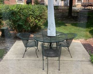 Like new outdoor wrought iron table, four chairs, umbrella and stand. Presale $150 for all.