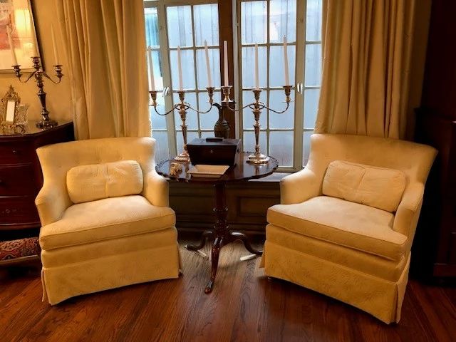 Pair of lovely stuffed arm chairs with antique tilt top table.  Pair of silver plate candelabras.