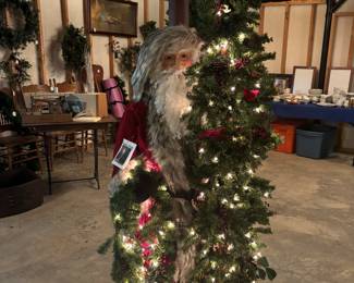 “Father Christmas” by Dietz Design Tuscany Christmas. 2 pc numbered work. On wood base. Santa is 58”, tree is 72”. With lights. 