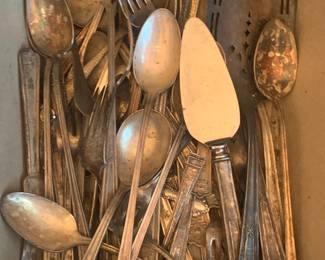 Multiple sets of silver flatware and silver serving pieces