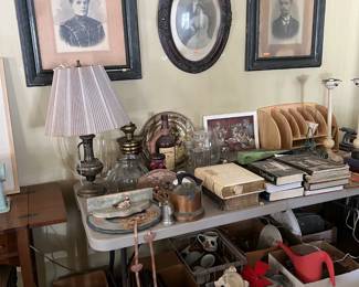 On the wall here are some framed portraits!  On the table are a mish-mash of other items often found in 