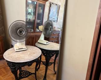 This shows the other wall-mounted mirror, plus a marble  table and a short fan.