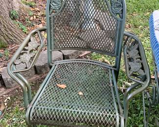 Outdoors in back of the house - 2 stacked metal chairs