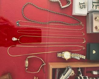 14k jewelry, 14k Bulova watch laying on side