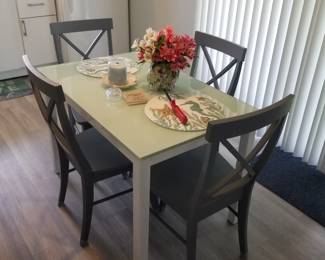 Dining table seats 6; 4 chairs shown, 6 available. Table extends on both ends to accommodate extra chairs.