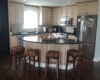 Handsome kitchen cabinetry by KountryKraft; bar stools