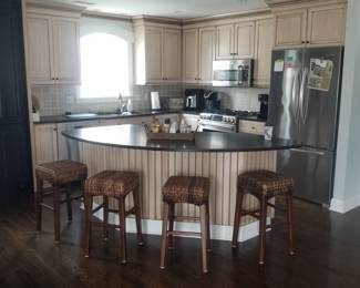 Handsome kitchen cabinetry by KountryKraft; bar stools