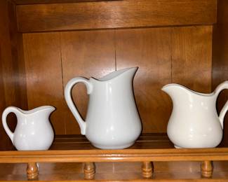 White pitchers in graduated sizes could blend with a variety of styles and colors. 