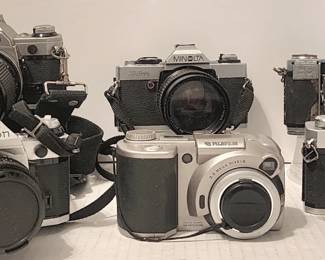 Camera collection includes:  Canon AE-1 with Canon 135mm lens and autowinder, Canon AE-1 with 50mm lens, Minolta XG-A with JCPenney 52mm lens, Fujifilm digital camera, Zeiss Ikon Contessa and a vintage Sears TLS (not pictured: Canon demi EE17)