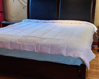 Espresso wood king-size bed with faux black leather headboard. Comes with a head and footboard and side rails. Small nick in the wood at the side, see photo.