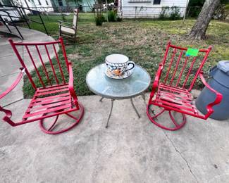 Red swivel rocking patio chairs, table, planter