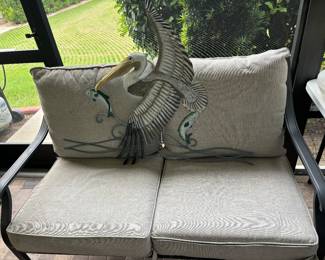 Pelican resting on loveseat after catching a fish.