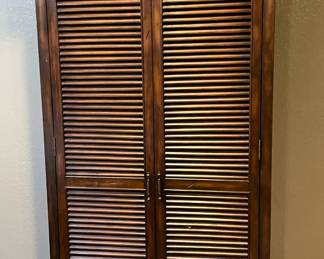Louvered wood doors with six shelves.  Great storage.
