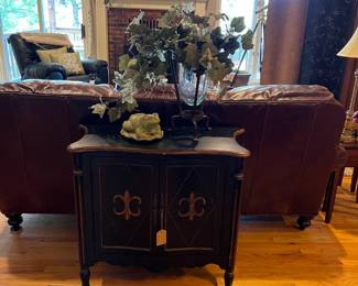 Black Fleur De Lis Painted wooden cabinet, brown leather sofa
