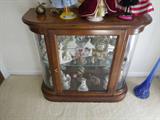 Small curio cabinet with rounded glass on both ends.
