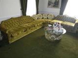 3 piece yellow/chartruse green sectional. The fabric is crushed velvet. There are accent pillows and a fabric cover coffee table with glass top.