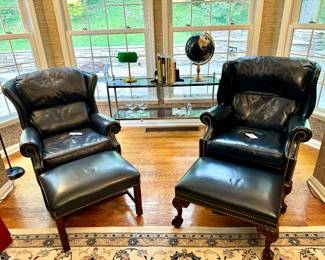 $450; (left with straight legs) navy blue leather chair and ottoman with nailhead trim; chair: 32x30x40; ottoman: 25x19x16.       $450; (right with claw feet) navy blue leather chair and ottoman with nailhead trim; chair: 32x33x40; ottoman: 25x19x16.    $300; chrome and brass console table with smoky colored glass top and bottom shelf; 52x15x31
