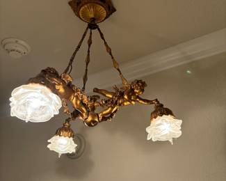 Gold gild French light fixture with angels and frosted flower petals. 