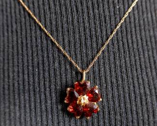 14k gold chain with pendant containing what appears to be garnets. Approx. weight is 2.54 grams and chain length at 16''.