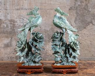 A pair of Dushan Nephrite Jade Phoenix sculptures. These sculptures feature birds perched amid foliage and are mounted on intricately carved wooden bases circa 20th century.