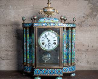 Chinese Cloisonné and canton enamel pendulum clock. The clock is in an overall neoclassical design having a cup and cover finial atop a dome flanked by pointed ball finials over a colonnade centering a dial enameled with Roman and Arabic numerals issuing a canton enameled pendulum with beauty portrait bust, flanked by two large enamel on copper figural plaques of westernized courtship scenes, on a conforming plinth raised on circular feet. Untested condition.